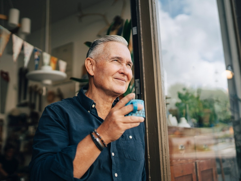 smiling business owner holding a cup of coffee